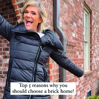 Brendt, brick influencer, poses in front of her brick home