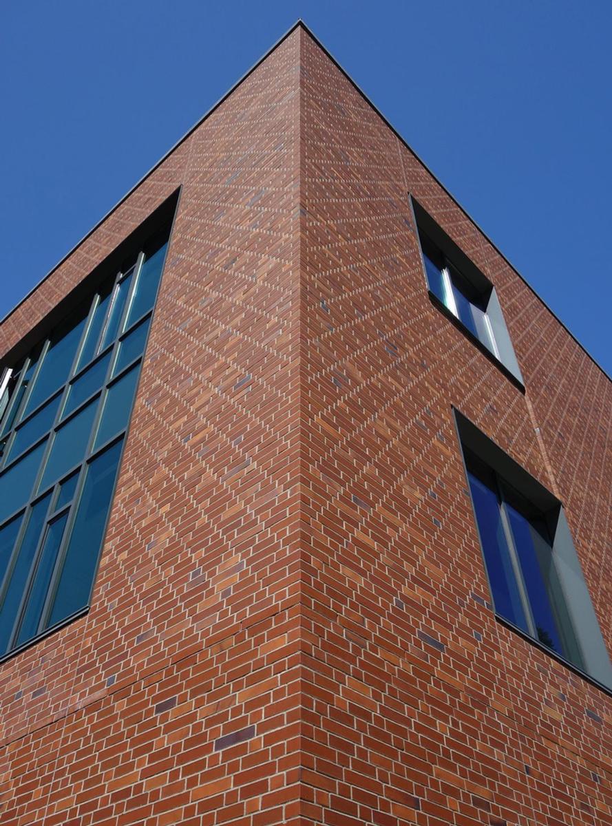 Image of the red bricked, windowed corner of the Willie and Don Tykeson Hall - University of Oregon building