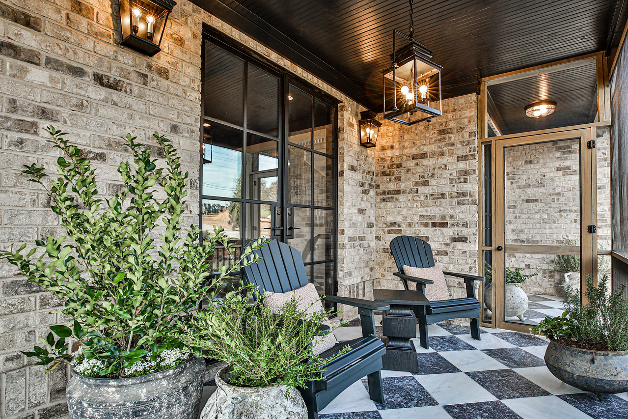 An outdoor patio with brick, chairs, and trees