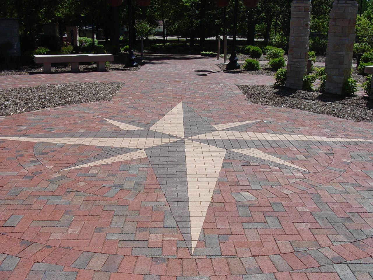 A brick paved walkway with a star design