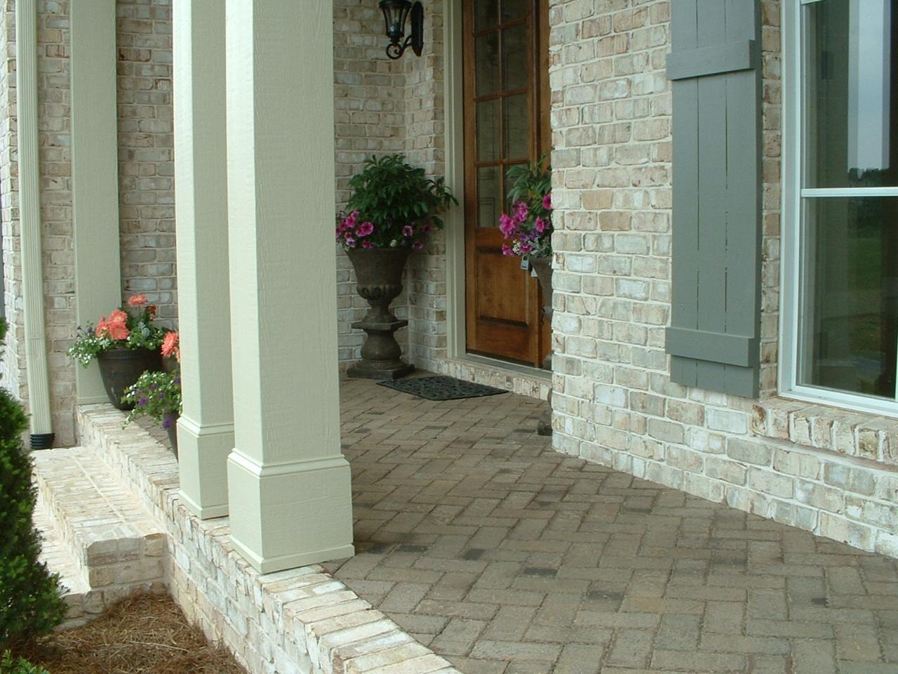 Image of a fully bricked porch with decorative plants and wooden columns