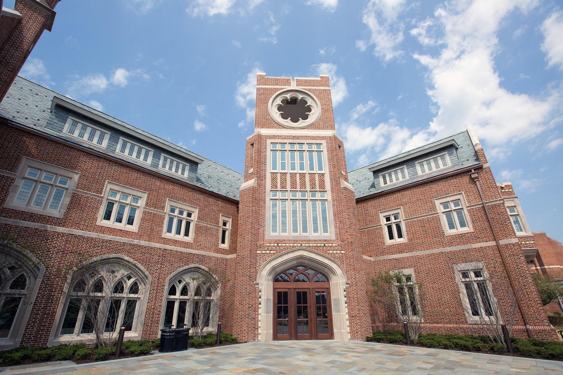 Image of a brown bricked and windowed wall at the Queally Admissions Center at the University of Richmond