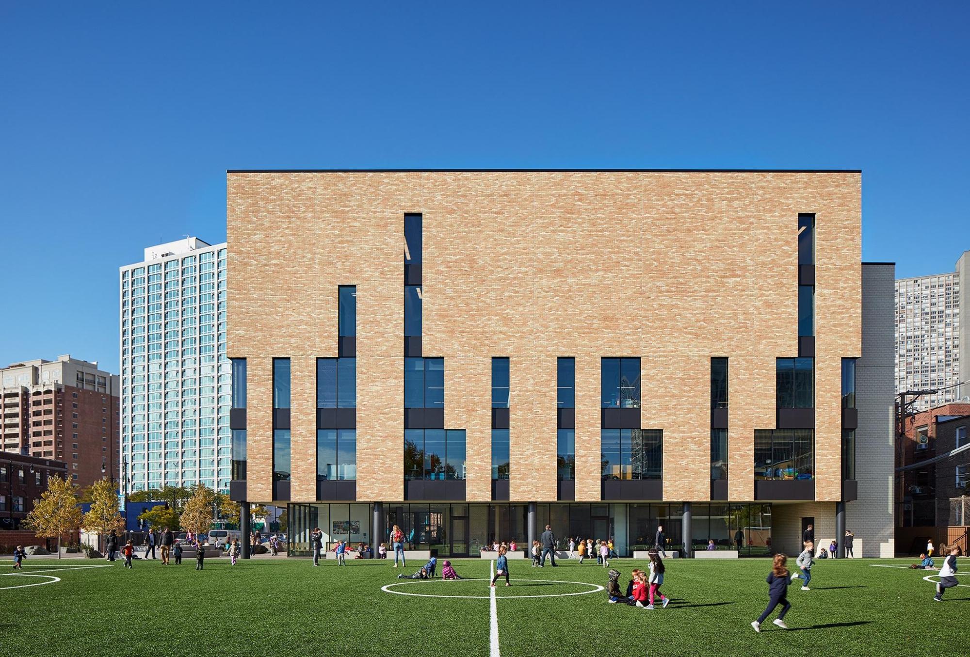 Exterior photograph of the Bernard Zell Anshe Emet Day School Expansion, featuring lightly colored bricks and green lawns