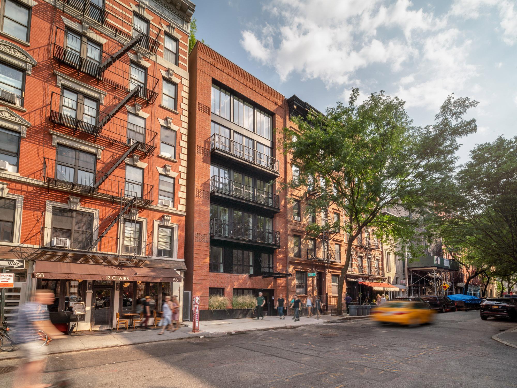Exterior image of the red bricked, sheltered by hardwood trees Soho Apartment Building