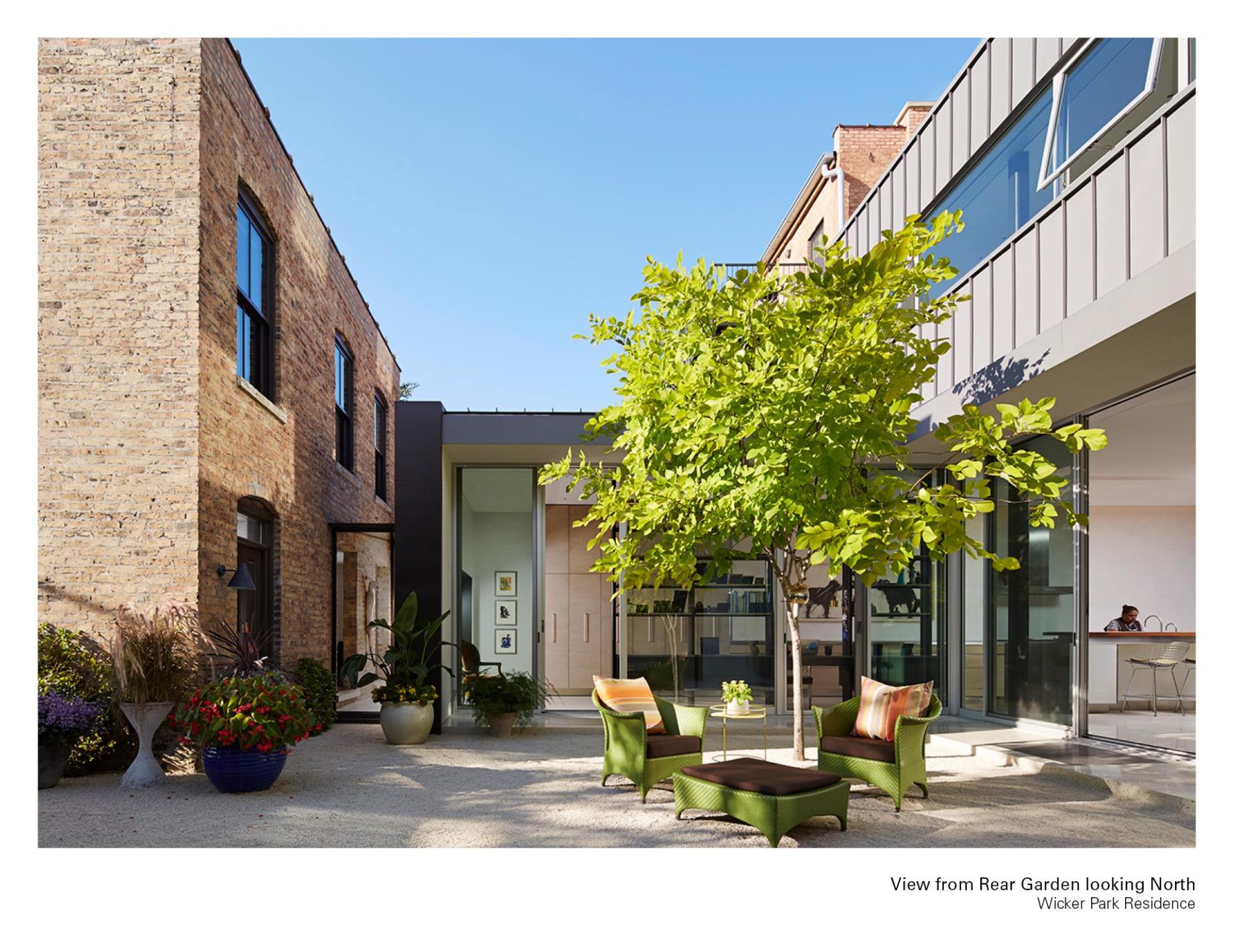 Image of the red brick, windows, and shrubbery taken from the outside of the Wicker Park Residence