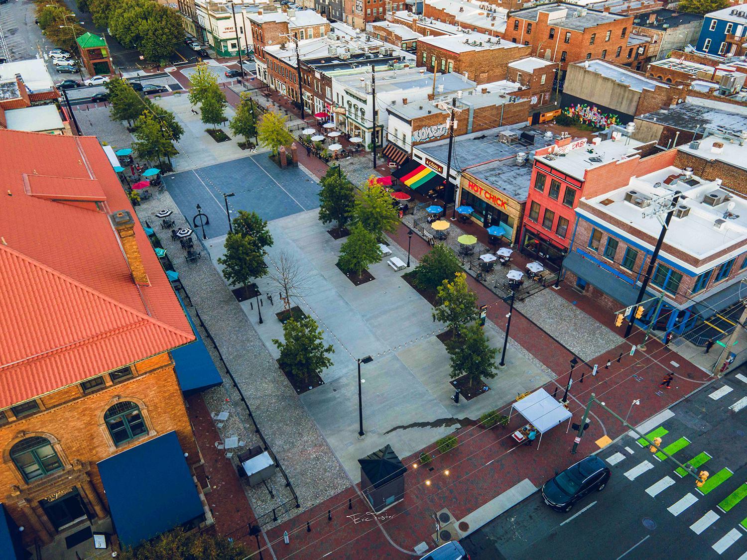 Overhead image of the 17th Street Market, featuring cars, brick walkways and buildings, and green plants