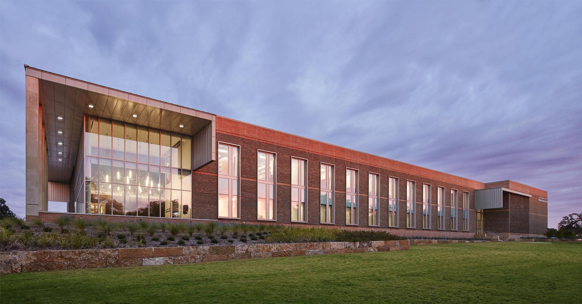 Exterior image of the red bricked Music Activities Center - Texas A&M University and the green lawn outside it