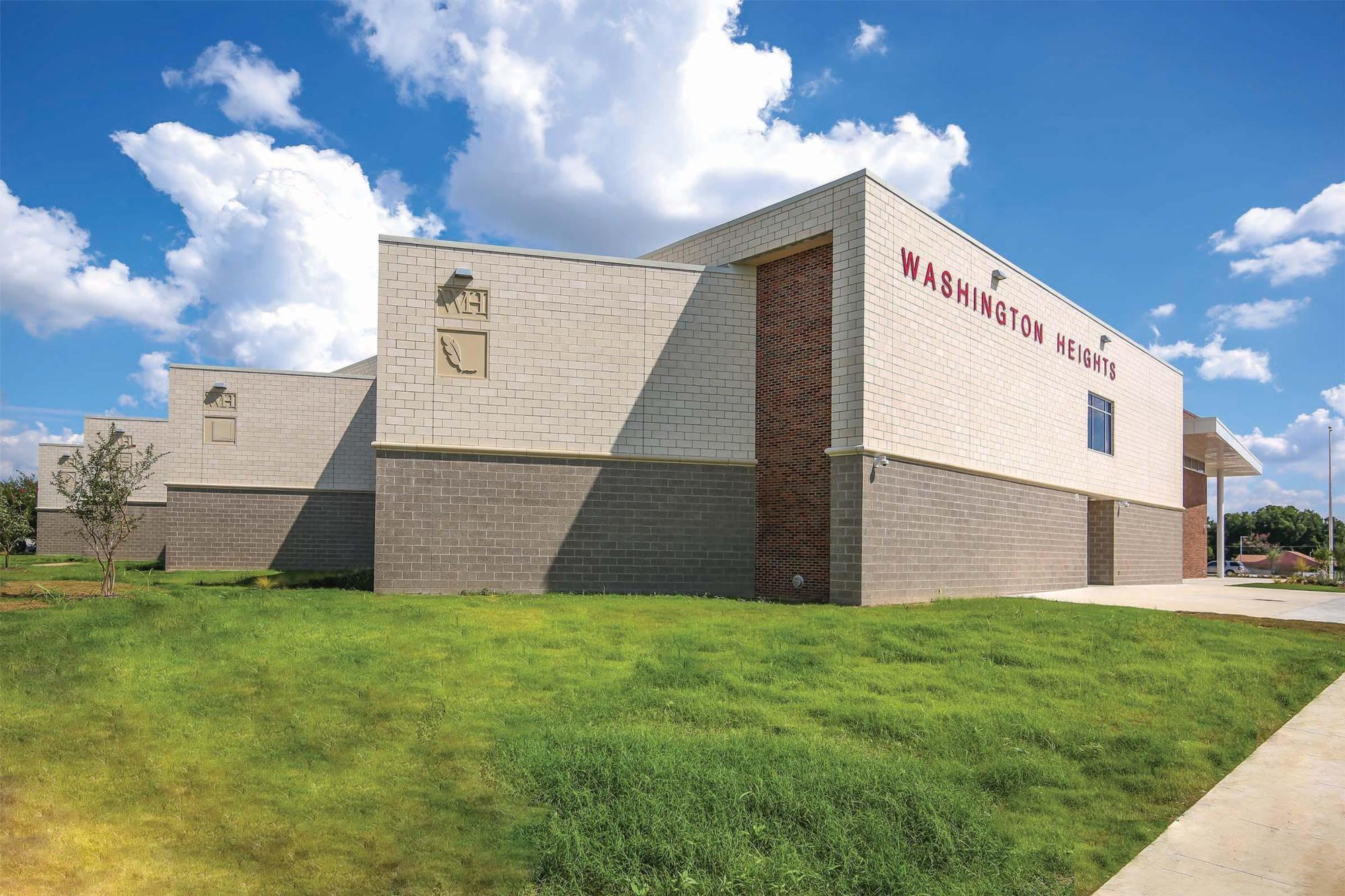 Image of the red and white bricked Washington Heights Elementary School and the lawn outside it