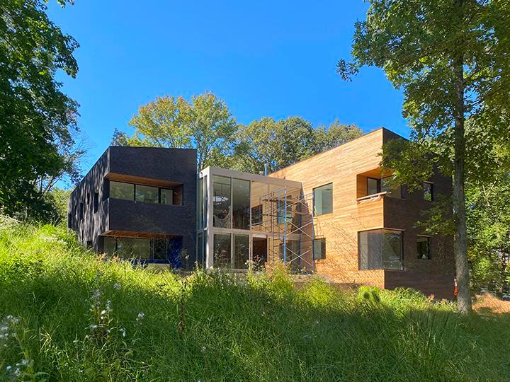 Image of the bricked exterior of the La Clairiere, a red bricked building surrounded by grass and trees