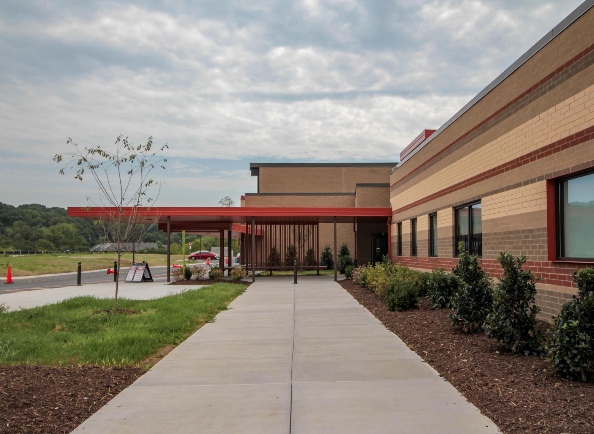 The outside of the bricked Eagle View Elementary School, with a concrete walkway, grass, and shrubbery