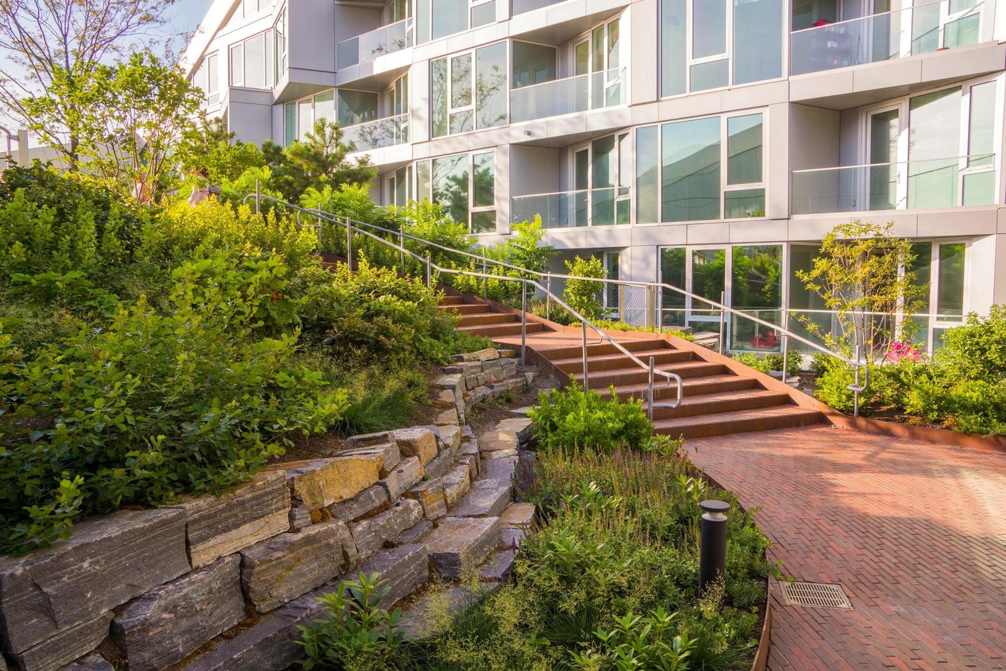 An image of the outdoor brick paving, walkways, walls, ornamental plants and building at VIA 57 West